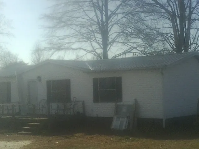 New metal roof on a white painted brick home on a foggy morning in Waverly